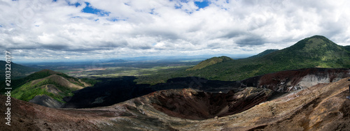 Panoramic view into the volcanic crater of Cerro Negro overlooking the Maribios mountain range and green plains in Leon, Nicaragua