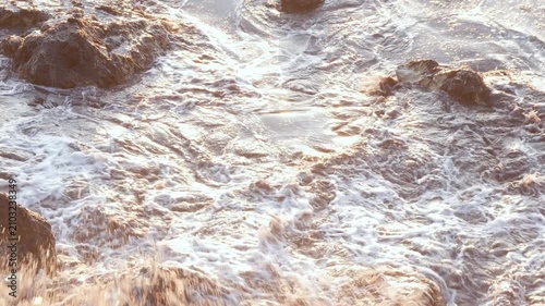 Rugged Seaside Rocks Surrounded by Foamy Ocean Waves at Sunset 