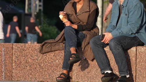 Young Adults Enjoying Ice Cream While Sitting Outdoors in the City