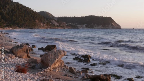 Rugged Seaside Rocks Surrounded by Foamy Ocean Waves at Sunset 