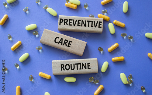 Preventive care routine symbol. Concept words Preventive care routine on wooden blocks. Beautiful purple background with pills. Healthcare and Preventive care routine concept. Copy space.