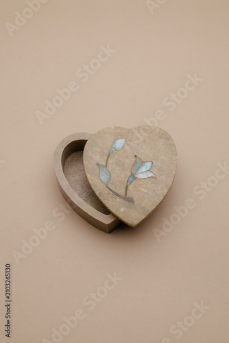 фотографія Elegant heart-shaped stone trinket box with delicate floral inlay, partially ope