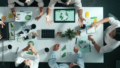 Obraz na płótnie Time lapse of business team discussing about using clean energy and sustainable investment at meeting table with wind mill, document with environmental graph and wooden house model
