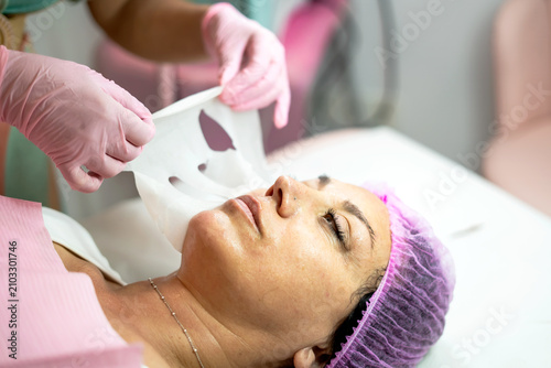 фотографія Woman receiving hydrating sheet mask facial treatment