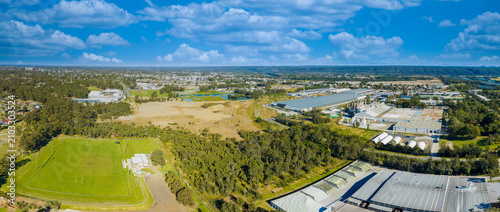 Bild auf Leinwand Drone aerial panoramic photograph of industrial buildings and a sports field sur