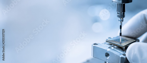 Microchip manufacturing probe testing a silicon chip in cleanroom conditions.