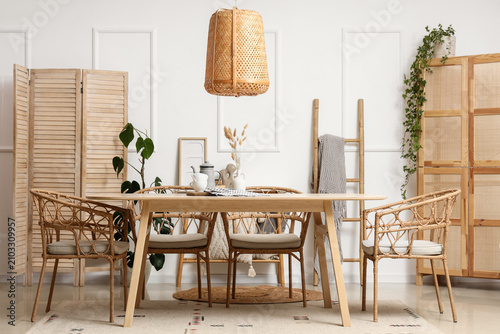 Fotografia Interior of light dining room with wooden table, folding screen and ladder