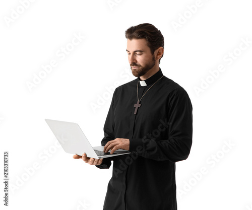 Bild auf Leinwand Handsome priest using laptop on white background