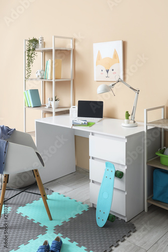 Interior of childrens room with workplace and shelf units