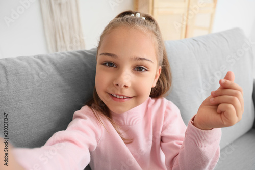 Cute little girl taking sel...