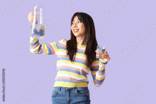 Young Asian woman with jug ...