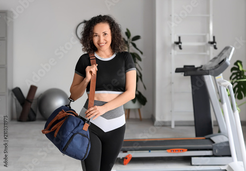 Mature woman with sports bag at gym