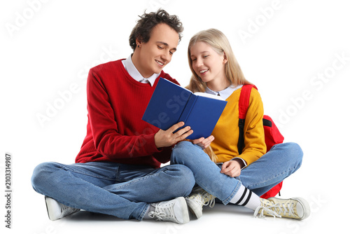 Teenage couple reading book...