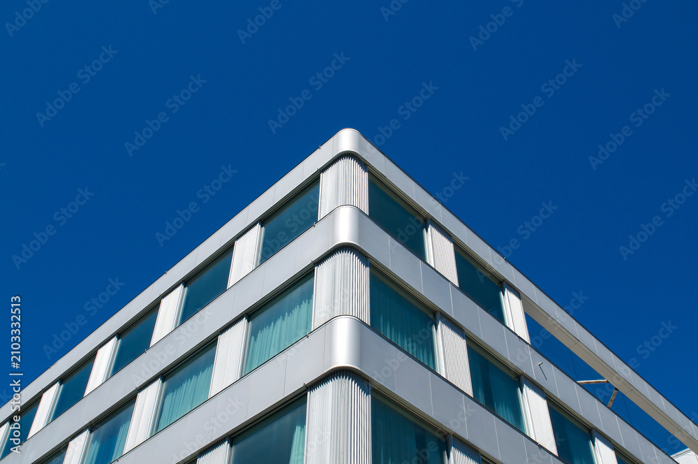 Obraz premium Modern corporate building facade corner under clear blue sky