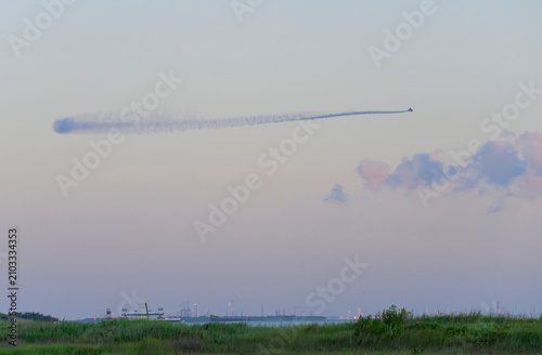 Aerial mosquito treatment from a plane at dawn over Galveston Island wetlands prior to the July 4 gathering, Galveston, Texas, USA.