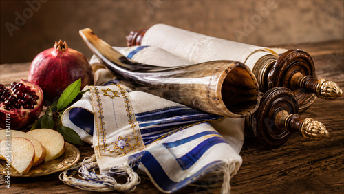 Rosh Hashanah Jewish New Year symbols with shofar, Torah scroll, tallit prayer shawl, pomegranate and apples.