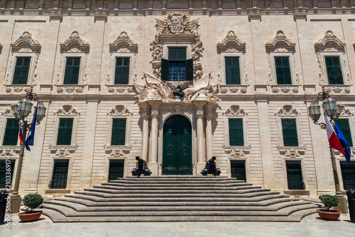 The grand Baroque facade of the Auberge de Castille with ornamental cannons and curved steps in Valletta, Malta