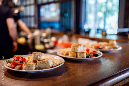 Breakfast items are ready on a counter in a busy cafe setting