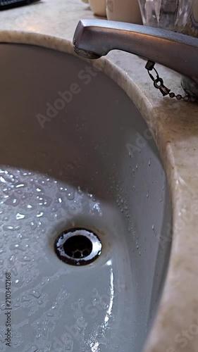 Canilla de baño vieja perdiendo gotas de agua en la bacha