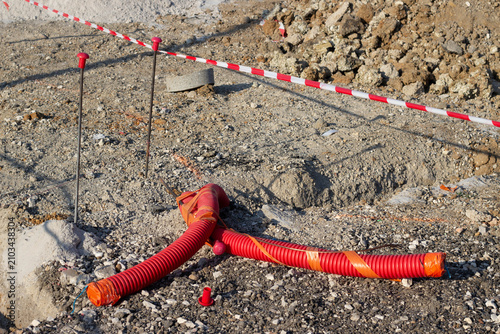 Foto Construction site with orange drainage pipes laid on gravel ground, surrounded b