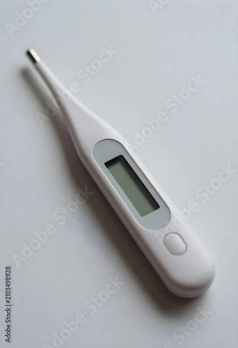 White digital medical thermometer with a blank screen for measuring body temperature, health care and illness