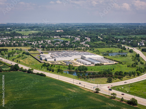 Aerial view of a modern data center facility with solar panels on the roof, cooling units and server buildings