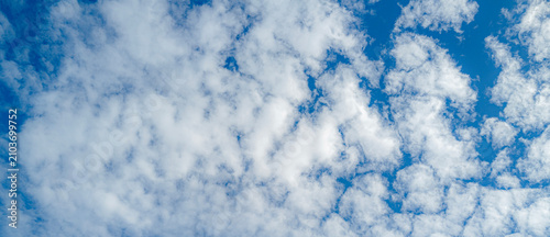 Foto Sun shining through the puffy clouds