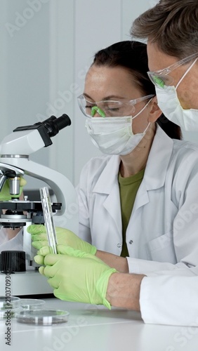 Fotografie Scientist working with microscope researching medical analysis discovering biolo