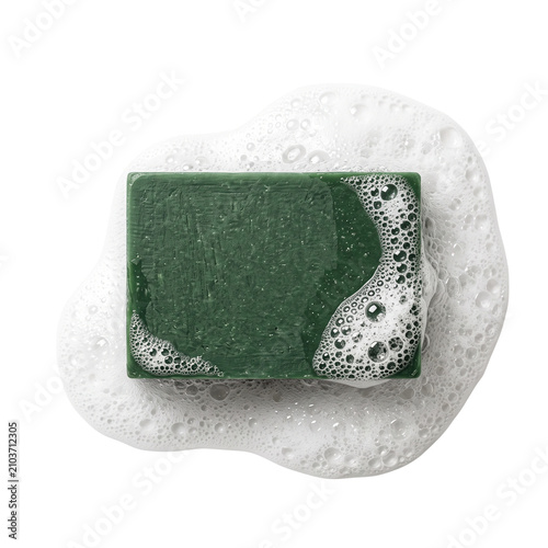 Green bar soap with white foam and bubbles on white background, top view