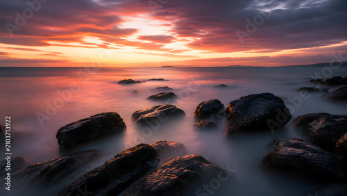 Long Exposure Sunset Seascape with Rocky Coast and Smooth Ocean Water