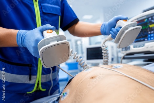 Emergency Medical Technician Using Defibrillator Electrodes During Patient Resuscitation in Ambulance, Advanced Life Support, Cardiac Emergency, EMS, Medical Care