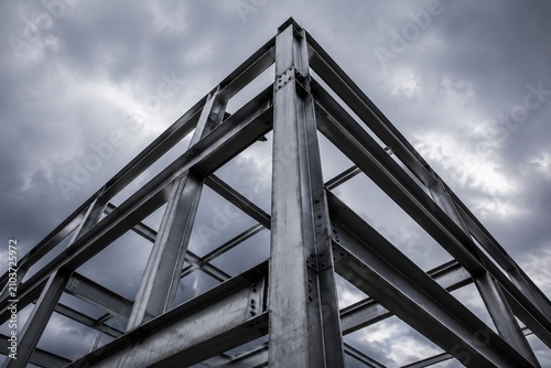 exposed. Industrial metal framework against cloudy sky, showcasing structural textures with dramatic lighting. travel magazines.