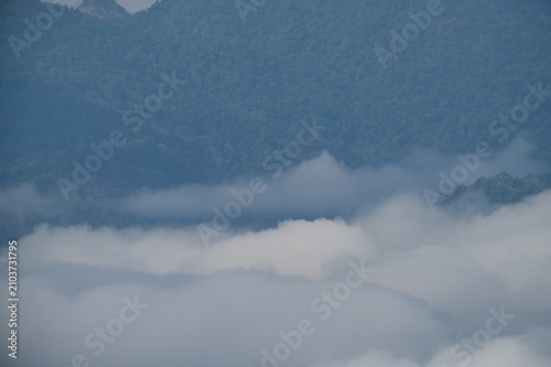 Breathtaking aerial view of misty valleys and lush green tropical rainforest mountains at dawn