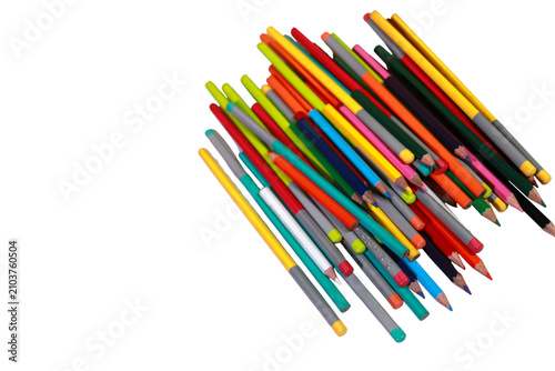 Vibrant wooden colored pencils are scattered randomly across a stark white background creating a colorful artistic mess of drawing tools.