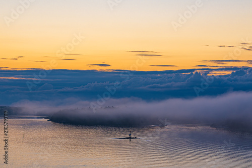 Inseln im Schärengarten mit Nebel und Sonnenaufgang vor Stockholm, Schweden