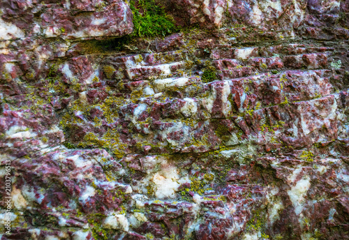 Close-up of textured surface of sealing wax jasper with purple and white mineral patterns
