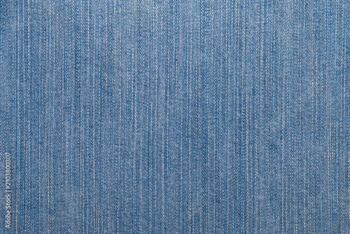 Fotografie Close-up of blue denim jeans fabric texture with visible woven threads and texti