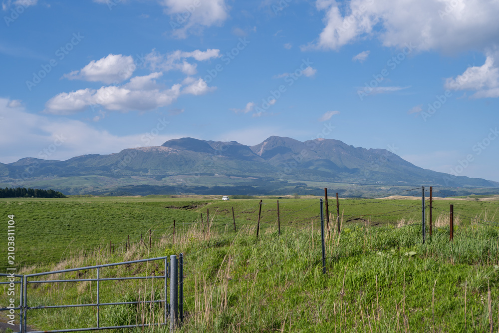 Fototapeta premium Vast Grassland Along Aso Milk Road and Kuju Mountain Range, Kumamoto, Japan