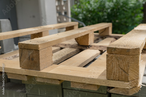 Bilde på lerret Wooden pallet on a surface with greenery in the background