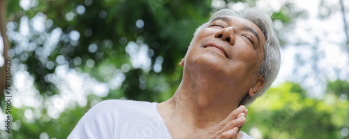 Foto Relaxed happy refreshing old retired senior Asian man taking a deep breath of cl