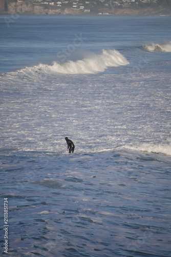 surfer in white water, cold water in winter Aotearoa New Zealand