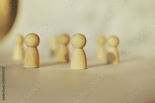 Wooden peg dolls representing a diverse business team and leadership
