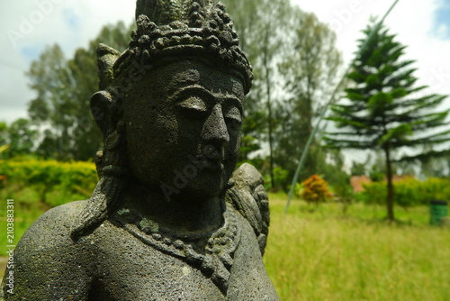 Принти на полотні Traditional stone statue of a Balinese deity with intricate carvings and weather