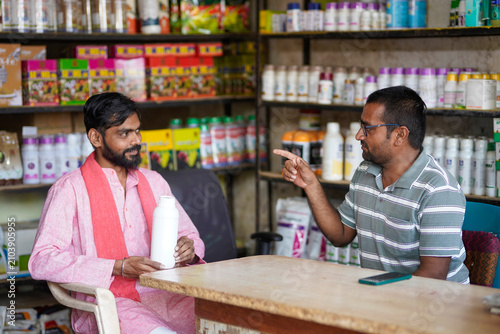 indian farmer and fertilizer shop owner discussing about best product at shop