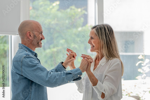 Bild auf Leinwand Cheerful caucasian mature couple holding hands, smiling and enjoying a joyful mo