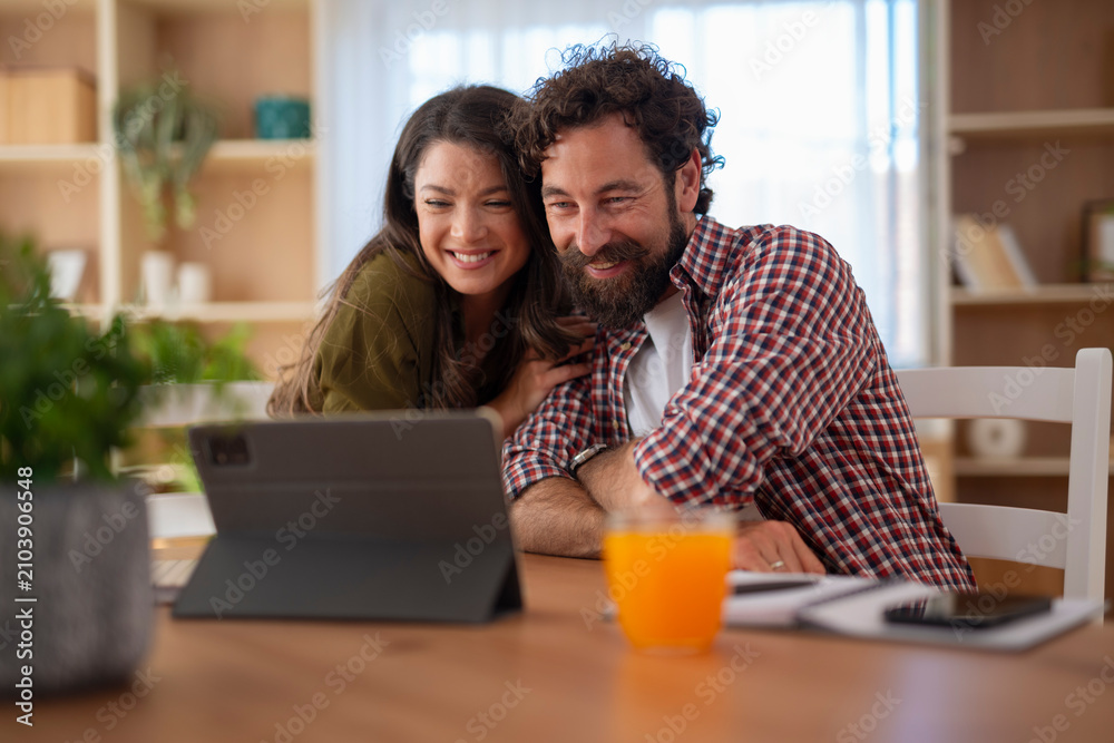 Fototapeta premium Happy couple enjoying video call on tablet together