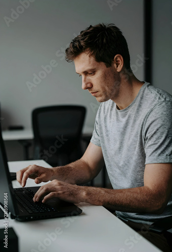 Focused young man typing on...