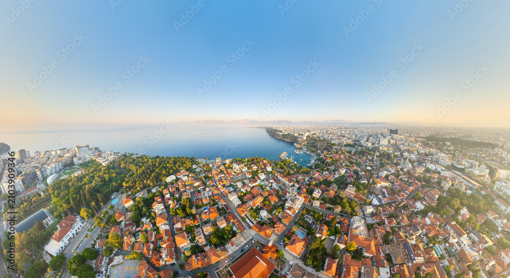 Fototapeta premium Antalya, Turkey. Kaleici Old Town terracotta rooftops sweeping toward the Mediterranean coastline, aerial panoramic view on a bright summer morning