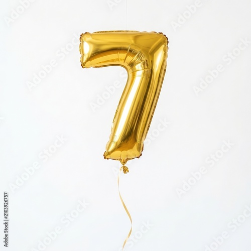 Golden number seven balloon floating in air. Shiny metallic party digit for celebrations and events.