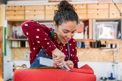 фотографія Woman upholsterer cutting fabric managing small business